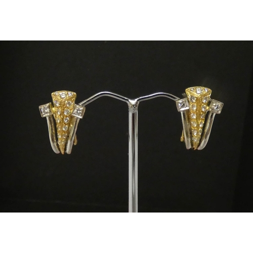 556 - A pair of modern 18ct bicolour gold and diamond earrings, with post and omega safety clip fastenings... 