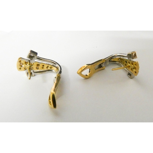 556 - A pair of modern 18ct bicolour gold and diamond earrings, with post and omega safety clip fastenings... 