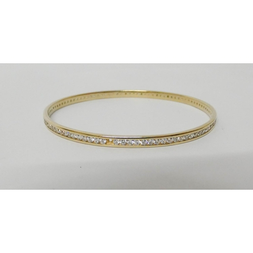 558 - A 9ct yellow gold bangle channel set with CZ stones, hallmarked, gross weight 10.6g