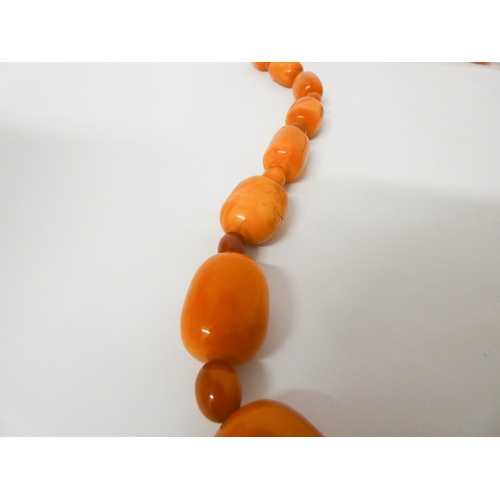 413 - Long Art Deco graduated row of butterscotch amber beads, gross weight 197 g