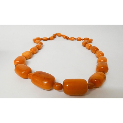 413 - Long Art Deco graduated row of butterscotch amber beads, gross weight 197 g