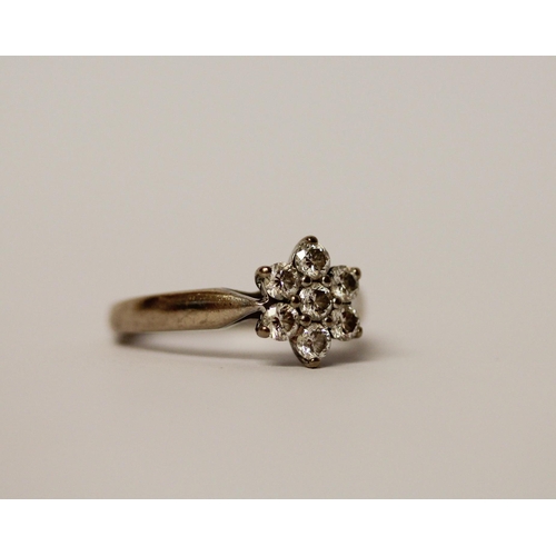 527 - A diamond daisy cluster ring, set seven diamonds on unmarked white precious metal band, ring size J,... 