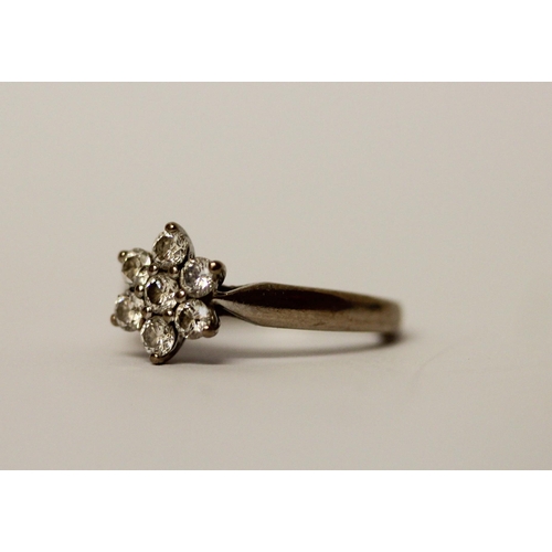 527 - A diamond daisy cluster ring, set seven diamonds on unmarked white precious metal band, ring size J,... 