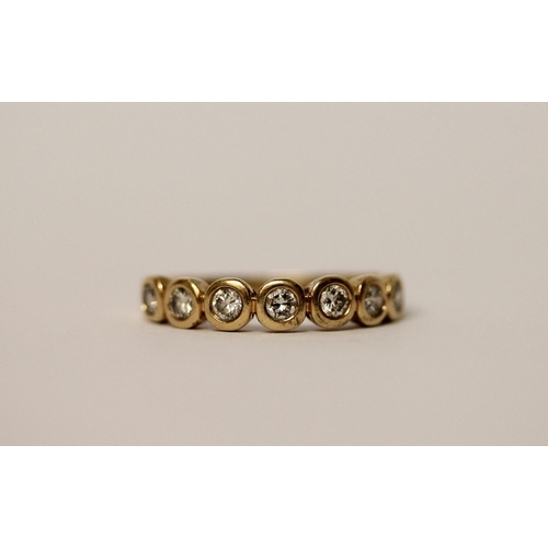 564 - A modern half hoop diamond eternity ring, set seven brilliant cut diamonds in rub over settings on 1... 