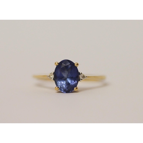 568 - A tanzanite oval ring flanked by two diamonds. On 18ct gold band, marked 750 18k, ring size L, weigh... 