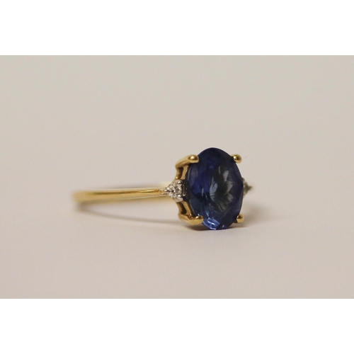 568 - A tanzanite oval ring flanked by two diamonds. On 18ct gold band, marked 750 18k, ring size L, weigh... 