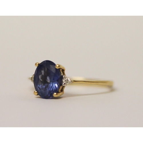 568 - A tanzanite oval ring flanked by two diamonds. On 18ct gold band, marked 750 18k, ring size L, weigh... 