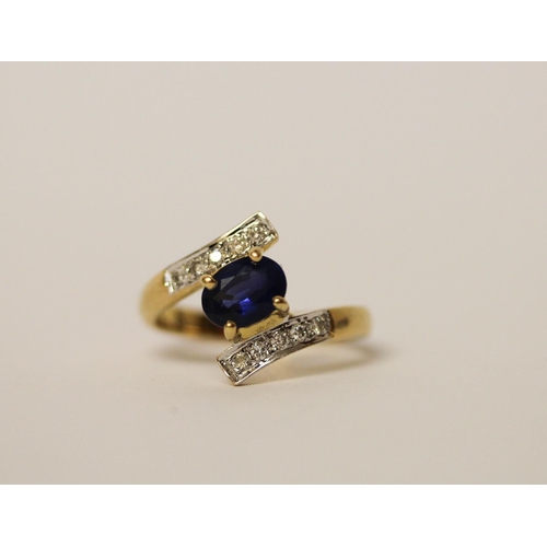 570 - A sapphire and diamond ring, in a twist cross over design, on  18ct yellow gold band, marked 750, ri... 