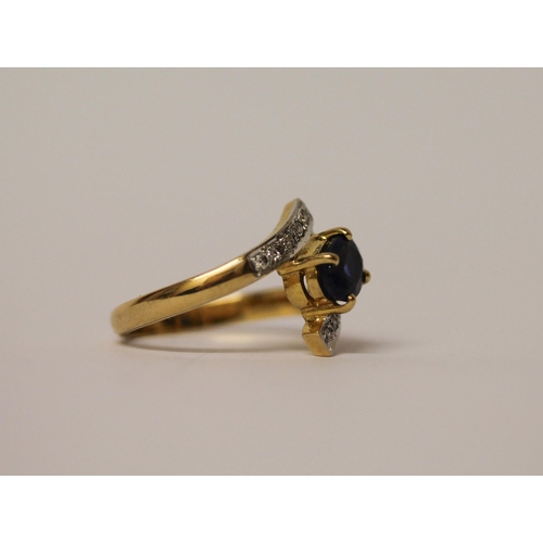 570 - A sapphire and diamond ring, in a twist cross over design, on  18ct yellow gold band, marked 750, ri... 