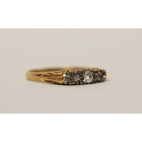 572 - An antique five stone diamond ring in a carved setting, band marked 18ct, ring size P, 3.5g