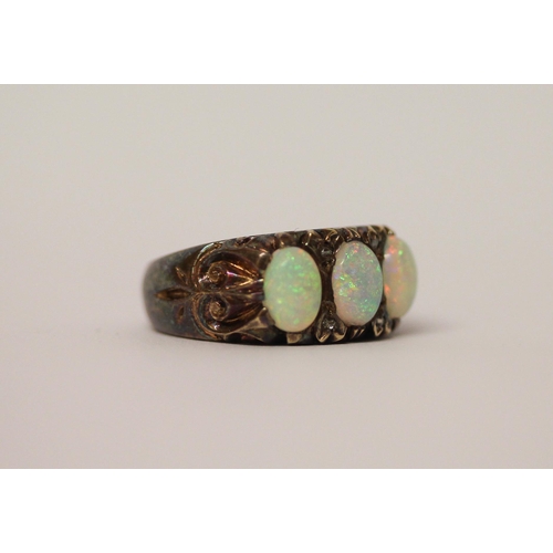 573 - An opal three stone and diamond ring, three large opals with good play of colour in 9ct gold setting... 