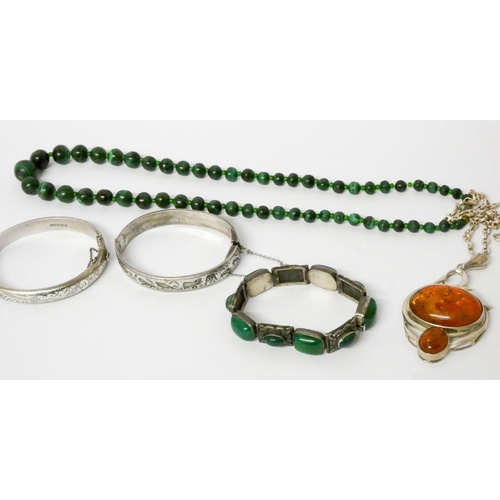 425 - A silver and amber chunky pendant on chain, silver bangle, malachite beads, green stone set bracelet... 