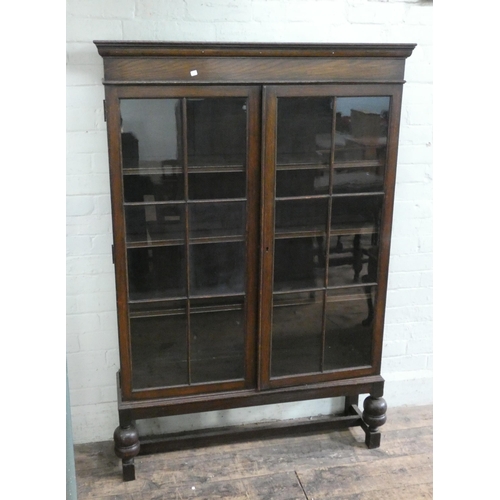 21 - An oak glazed two door bookcase on bulbous legs, 3'6 wide, 5'3 tall