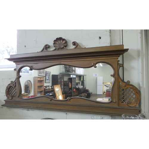 51 - A shaped over mantle mirror in decorative frame, 4' wide