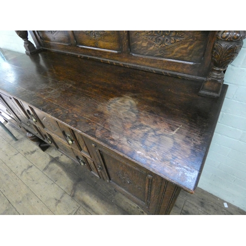 8 - A 1930's carved oak sideboard with low back, drawers and cupboards under, standing on bulbous legs, ... 