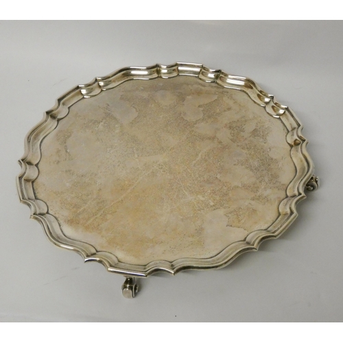 416 - A silver salver, with pie crust edge, raised on four scrolled feet, hallmarked London 1934, D & J We... 