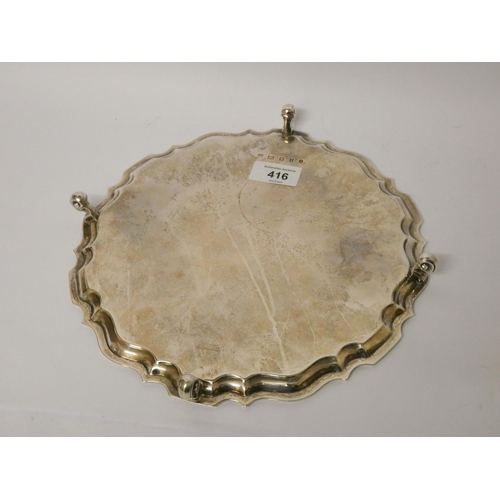 416 - A silver salver, with pie crust edge, raised on four scrolled feet, hallmarked London 1934, D & J We... 