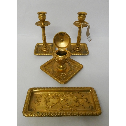 115 - A gilt metal four piece desk set of candlesticks, inkwell and pen tray in the oriental taste