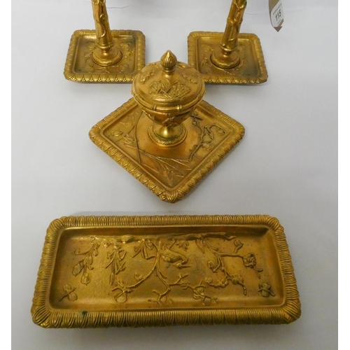 115 - A gilt metal four piece desk set of candlesticks, inkwell and pen tray in the oriental taste