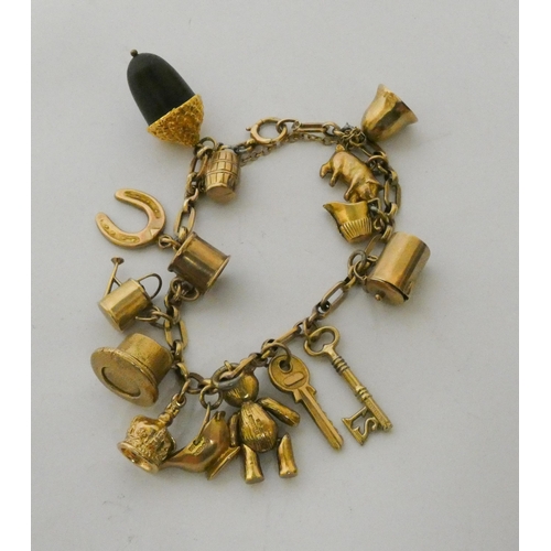 420 - A 9ct gold charm bracelet set a large acorn charm and numerous other gold charms. gross weight 26.3g