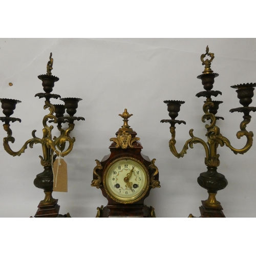 226 - A late 19th century French rouge marble and gilt metal mounted three piece clock garniture, candlest... 