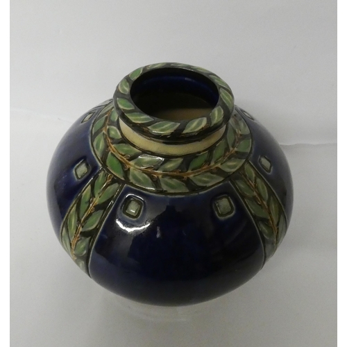 237 - A Doulton Lambeth stoneware pumpkin shaped vase decorated with bands of green leaves against a blue ... 