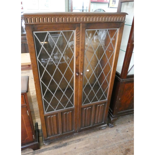 148 - An Ercol style oak leaded glazed bookcase with cupboards under, 31