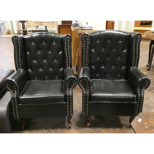 285 - A pair of buttoned wingback easy chairs in studded black faux leather