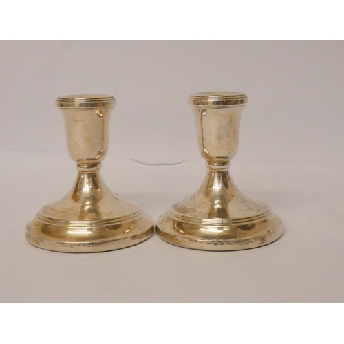 425 - A pair of silver circular based candlesticks, weighted, 11 cms high