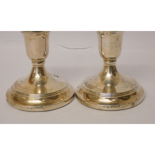 425 - A pair of silver circular based candlesticks, weighted, 11 cms high