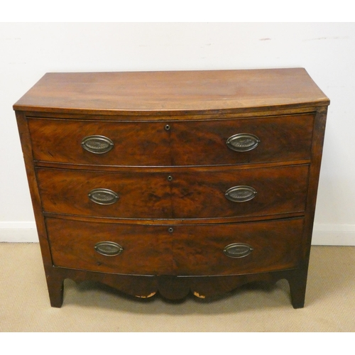 322 - A Georgian mahogany bow front chest of three long drawers with brass handles, standing on splayed br... 