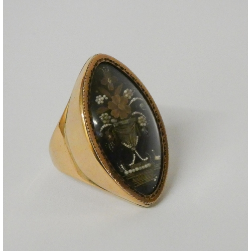 443 - A Georgian mourning ring, the navette shaped blue enamel panel painted and decorated in relief depic... 