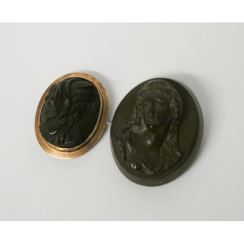 496 - Two Victorian carved bog oak cameo style brooches, the smaller in marked 9ct gold frame