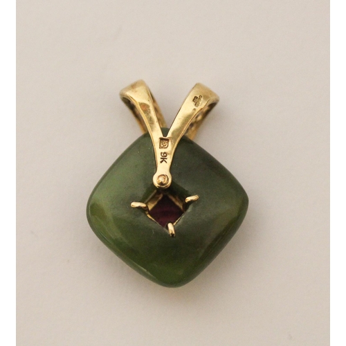 498 - A carved jade pendant with a central garnet with 9ct gold suspension loop