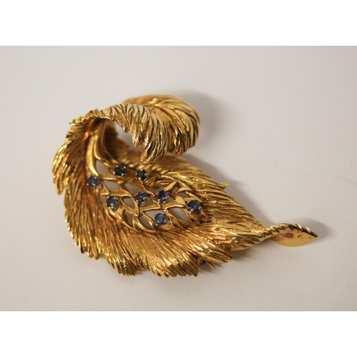 516 - A 14ct yellow gold leaf shaped brooch set with sapphires, circa 1965, 5.5 cms long, import marked an... 