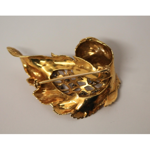 516 - A 14ct yellow gold leaf shaped brooch set with sapphires, circa 1965, 5.5 cms long, import marked an... 