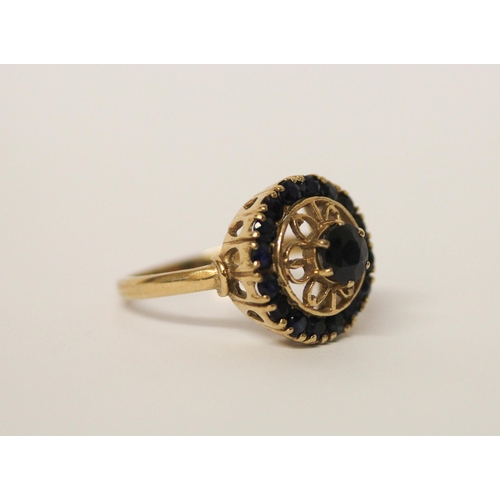 517 - A circular sapphire cluster ring on hallmarked 9ct gold band, ring size  T, weight 5g