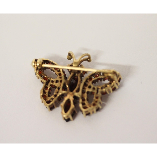 528 - A vintage style garnet set butterfly brooch, in yellow 9ct gold, marked 375, gross weight 3.8g, diam... 