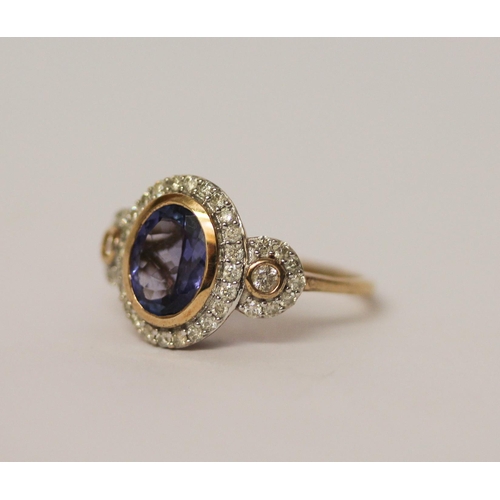 535 - A tanzanite and diamond three panel dress ring, with a large central oval rub over set tanzanite fla... 