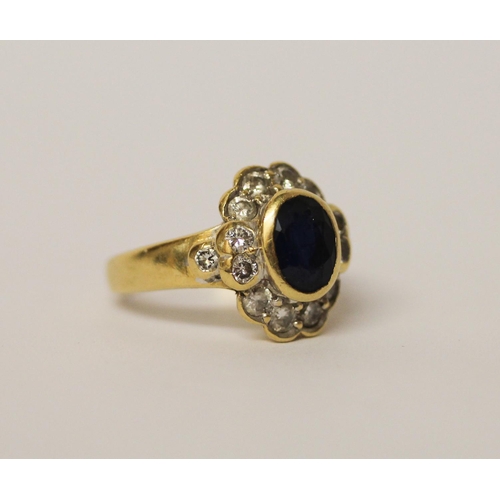 515 - A sapphire and diamond oval cluster ring in a rub over setting, 18ct yellow gold band, ring size K, ... 