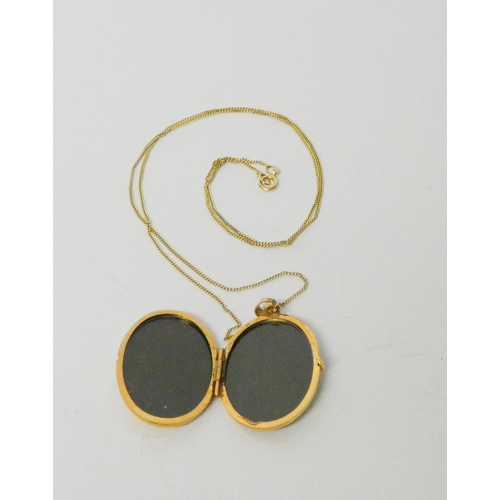 469 - A modern 9ct gold oval locket with engraved decoration to one side, on fine 9ct gold chain, gross we... 