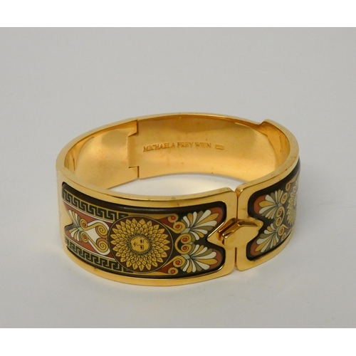 511 - An enamel hinged bangle by Michaela Frey, the 23mm wide yellow metal bangle with Art Nouveau style e... 