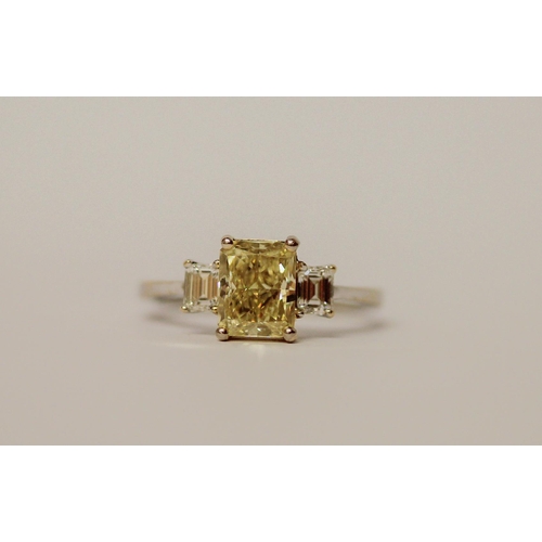 534 - A yellow and white three stone diamond ring, the central radiant cut fancy intense yellow diamond we... 