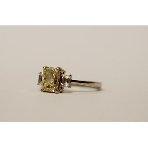 534 - A yellow and white three stone diamond ring, the central radiant cut fancy intense yellow diamond we... 