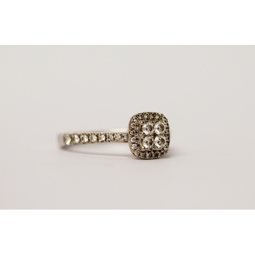 552 - A diamond cluster ring, set with four principal diamonds in a square panel, halo set with further di... 