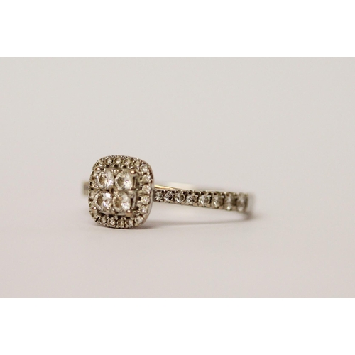 552 - A diamond cluster ring, set with four principal diamonds in a square panel, halo set with further di... 