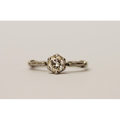 553 - A solitaire diamond ring, the brilliant cut diamond claw set to shaped shoulders in platinum setting... 