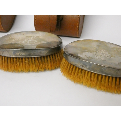 430 - Two pairs of vintage gents hairbrushes with engraved armorial, within leather cases