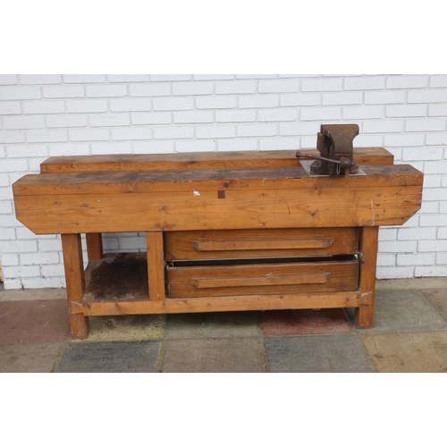 692 - A heavy robust wooden workbench fitted two large drawers with engineers vice, 72