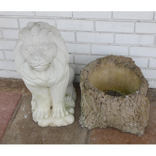 700 - A reconstituted stone garden ornament of a lion together with a stone tree stump shaped planter...